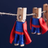 Super team concept photo with clothespin superheroes in blue suit and red cape. Big small powerful heroes. Dark background. soft focus. macro view, shallow depth of field Super team concept photo with clothespin superheroes in blue suit and red cape. Big small powerful heroes. Dark background. soft focus. macro view, shallow depth of field